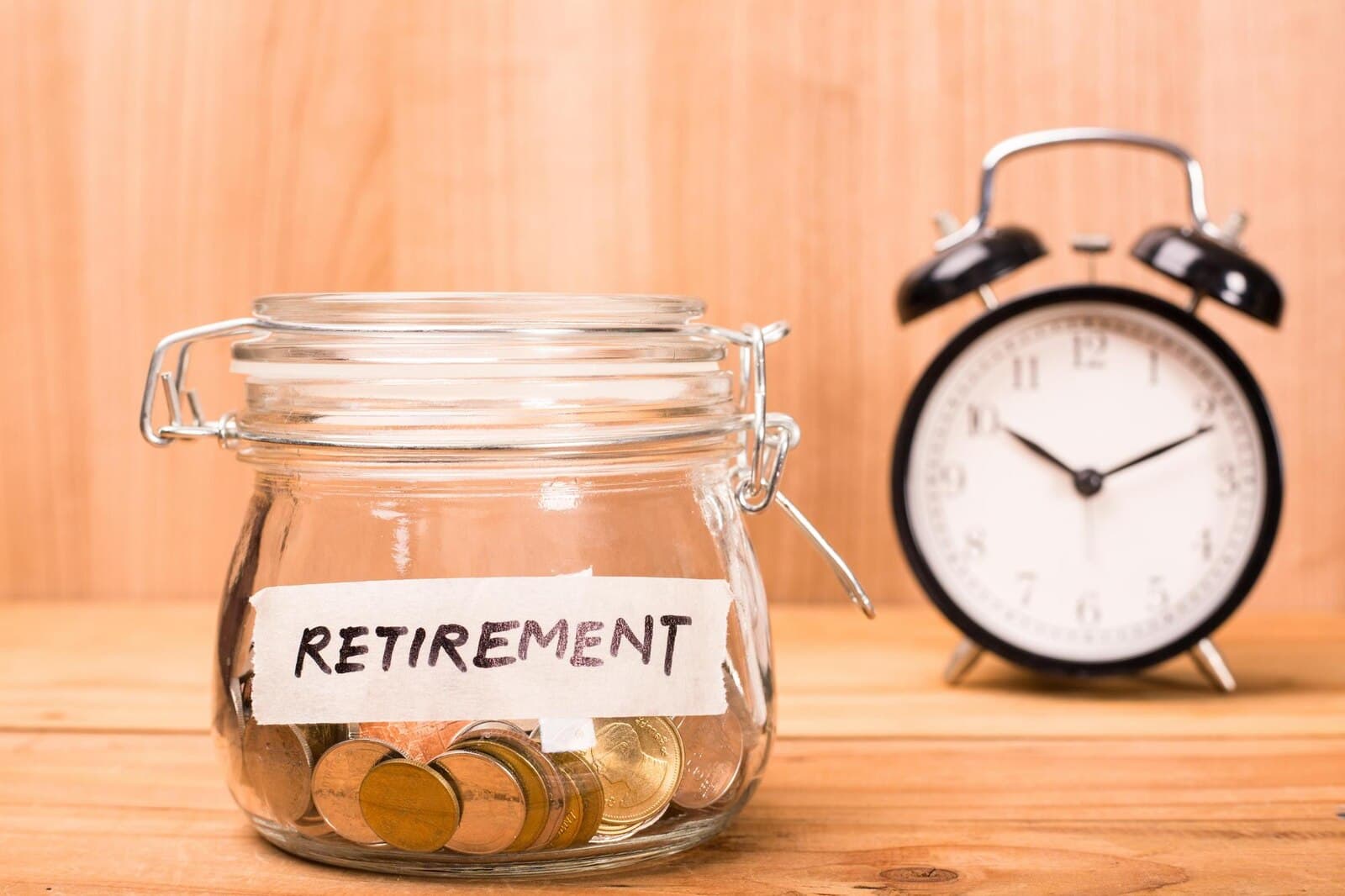 Sloik z napisem retirement i zegar - oszczedzanie na emeryture na koncie IKZE